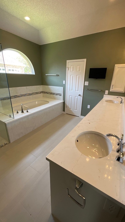 Modern bathroom renovation featuring arched window and dual vanity by Wade C