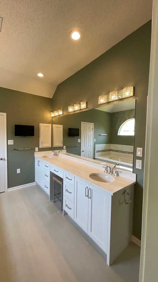 Modern bathroom renovation in San Antonio featuring white cabinetry and ligh