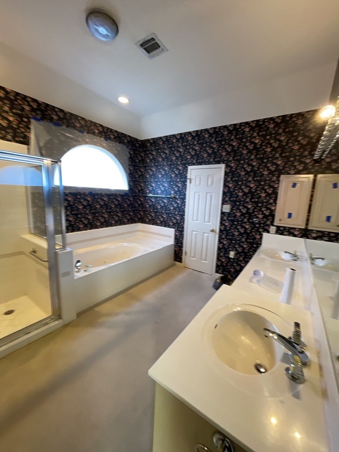 Elegant bathroom renovation in San Antonio with dual vanity and tub by Wade