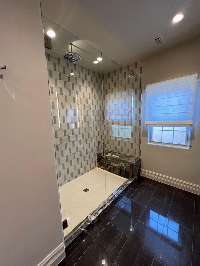 Frameless glass shower with modern tile in San Antonio bathroom remodel by Wade Caldwe