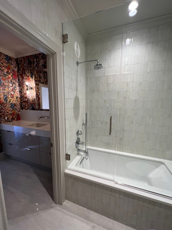 Modern bathroom renovation with tub and textured tile surround by Wade Caldwell Constr