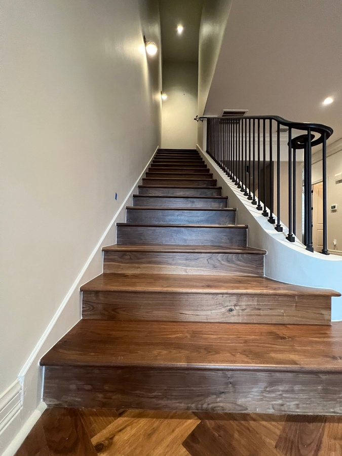 Staircase remodel with wood treads and iron railing by Wade Caldwell Construction in S