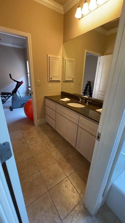Bathroom remodel in San Antonio featuring granite countertop and updated cabinetry by