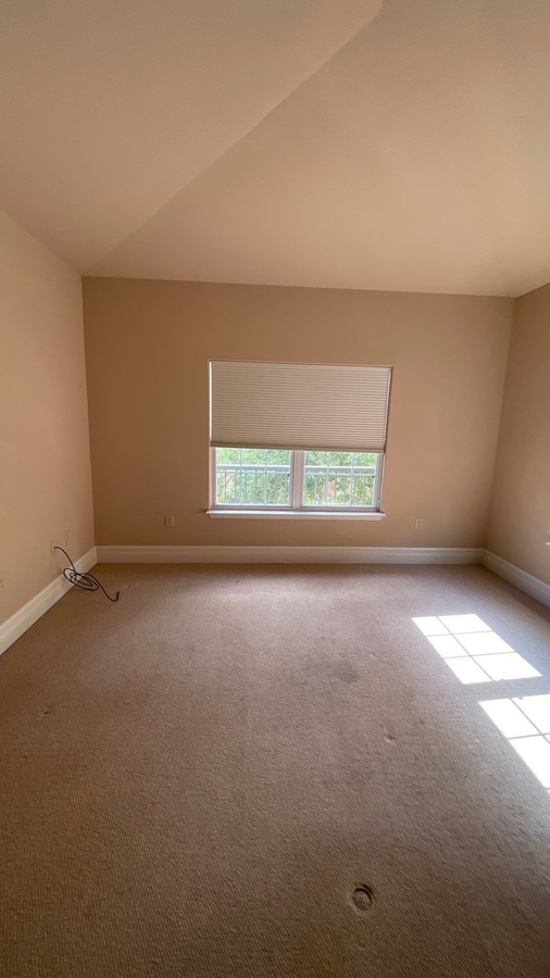 Empty carpeted bedroom with window view in San Antonio remodel by Wade Caldwell Const