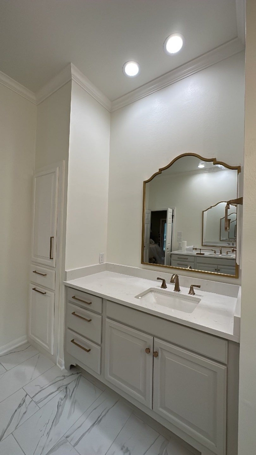 Quartz vanity with gold fixtures in Alamo Heights bathroom remodel by Wade Caldwell Constr