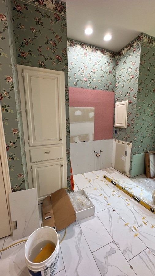 Bathroom remodel in progress with floor tile installation in Alamo Heights by Wade Caldwe