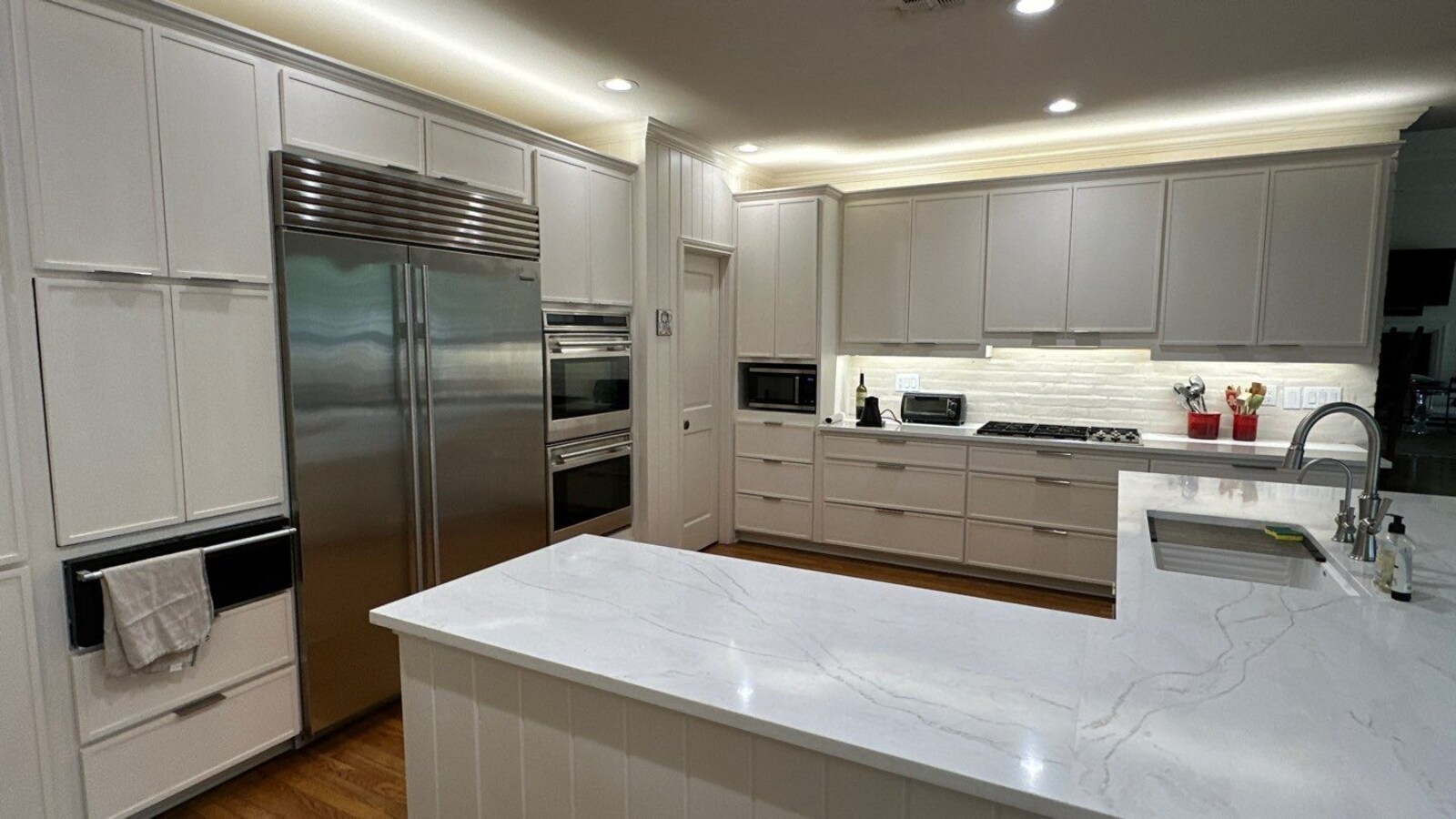 Open-concept kitchen in San Antonio featuring large island and stainless appliances by Wade Caldwell