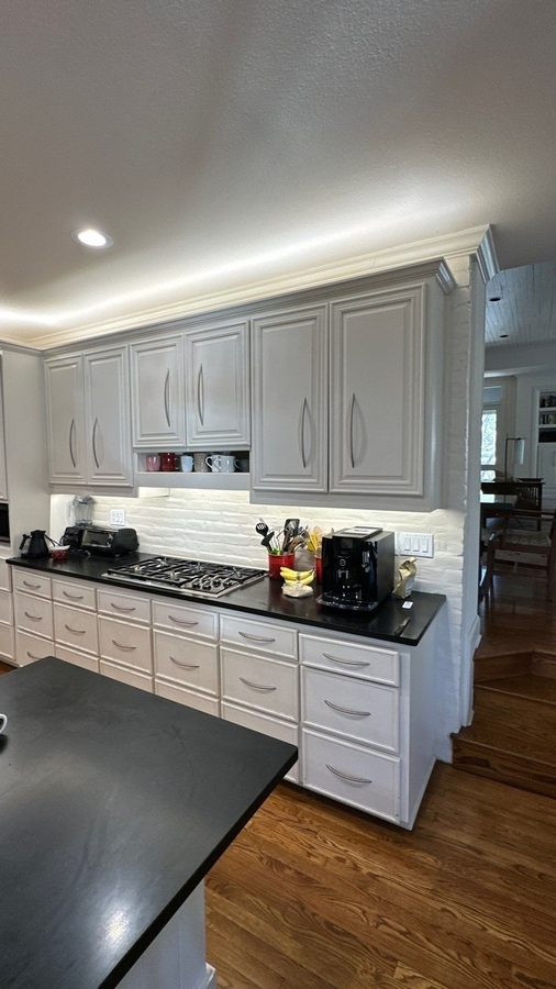 Custom kitchen remodel in San Antonio with soft gray cabinets and black countertops by Wad