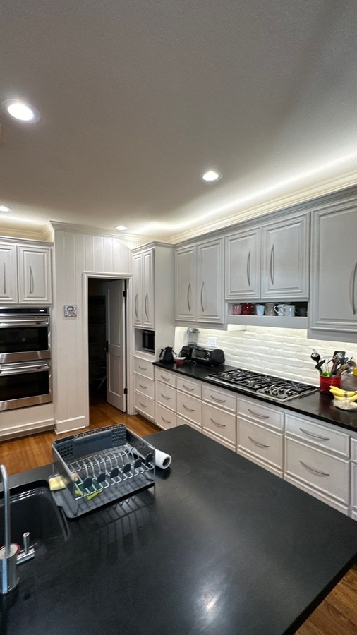 Transitional kitchen design with black surfaces and built-in appliances in San Antonio by 