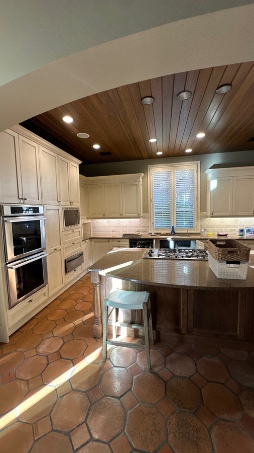 Full kitchen remodel with double oven, cooktop island, and detailed tile backsplash in Olmos Park