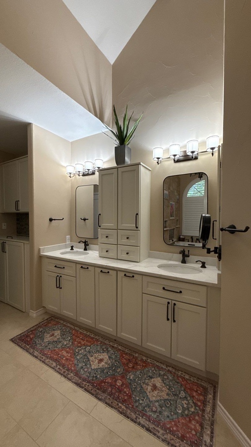 Dual sink vanity with custom cabinetry and black hardware in San Antonio bat