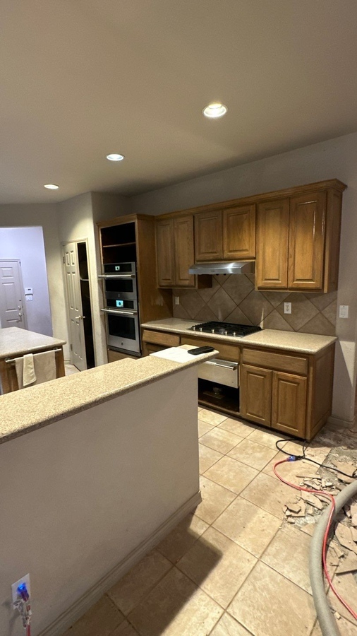 Kitchen in need of updates with old tile floors and cooktop island in San A