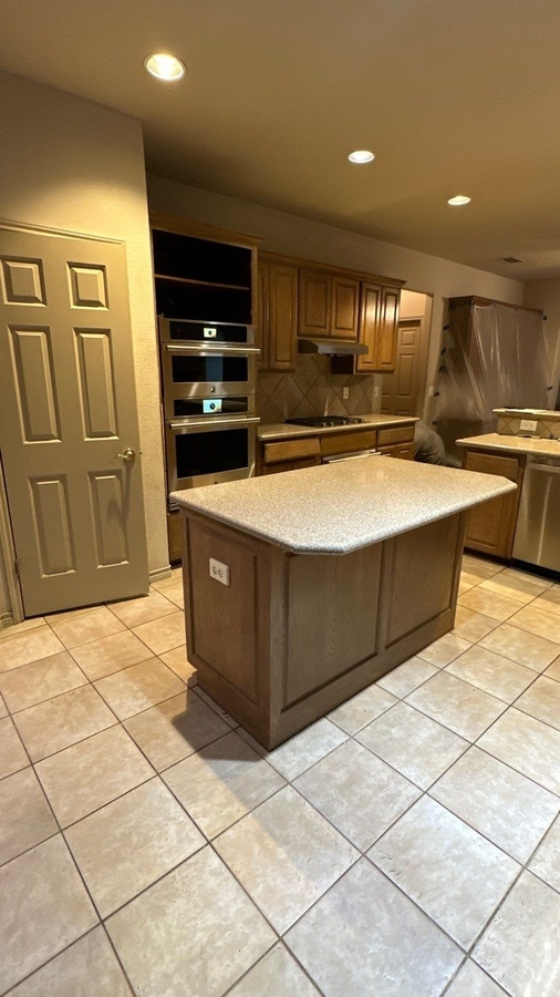 Kitchen island with laminate countertops and oak cabinetry in San Antonio b