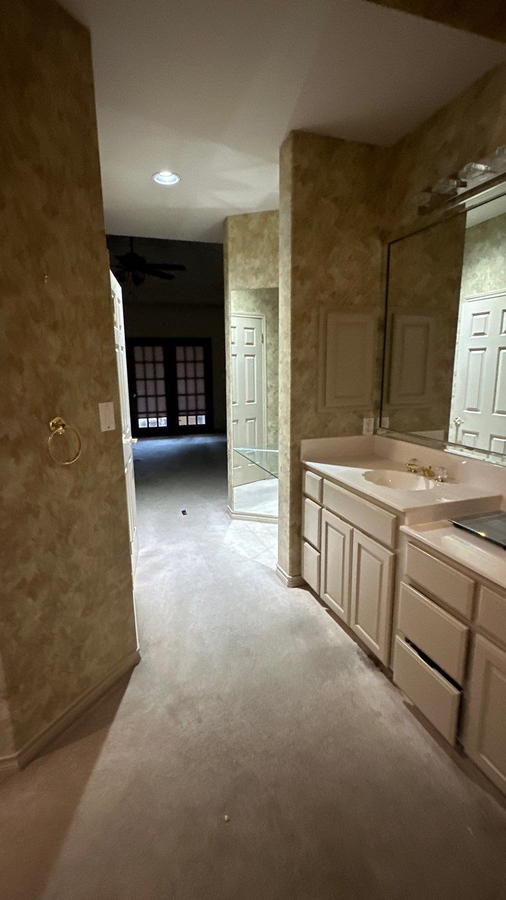 Outdated vanity space with mirrored wall and carpet flooring in San Antonio