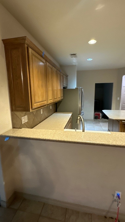 Pre-renovation kitchen with laminate counters and tile backsplash in San An