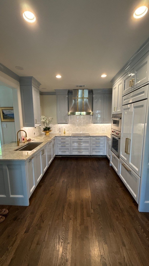 Full view of remodeled kitchen with gold hardware, quartz counters, and built-in appliances by 
