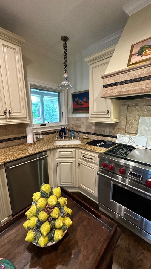 Elegant corner kitchen layout with neutral finishes and high-end appliances by Wade Caldwell C