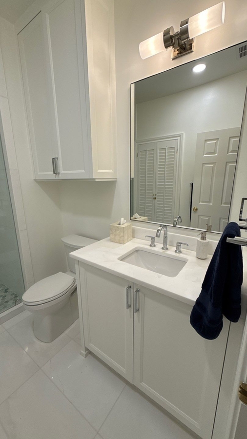 Elegant white bathroom vanity with quartz countertop and modern lighting in San Antonio