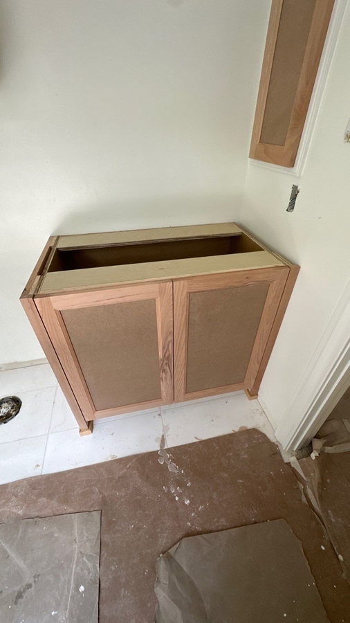 In-progress bathroom renovation with new wood vanity installation by Wade Caldwell Co