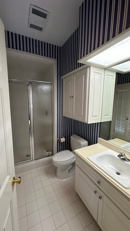 Traditional bathroom with striped wallpaper and walk-in shower remodel in San Antonio 