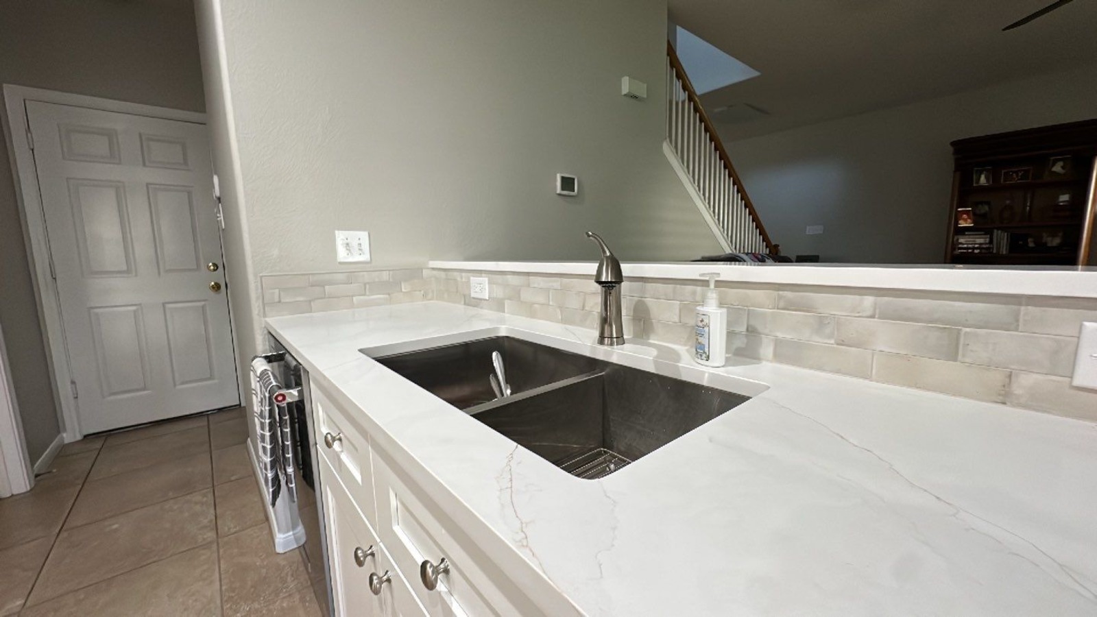 Close-up of stainless undermount sink with quartz counter in San Antonio kitchen remodel by Wade Cald