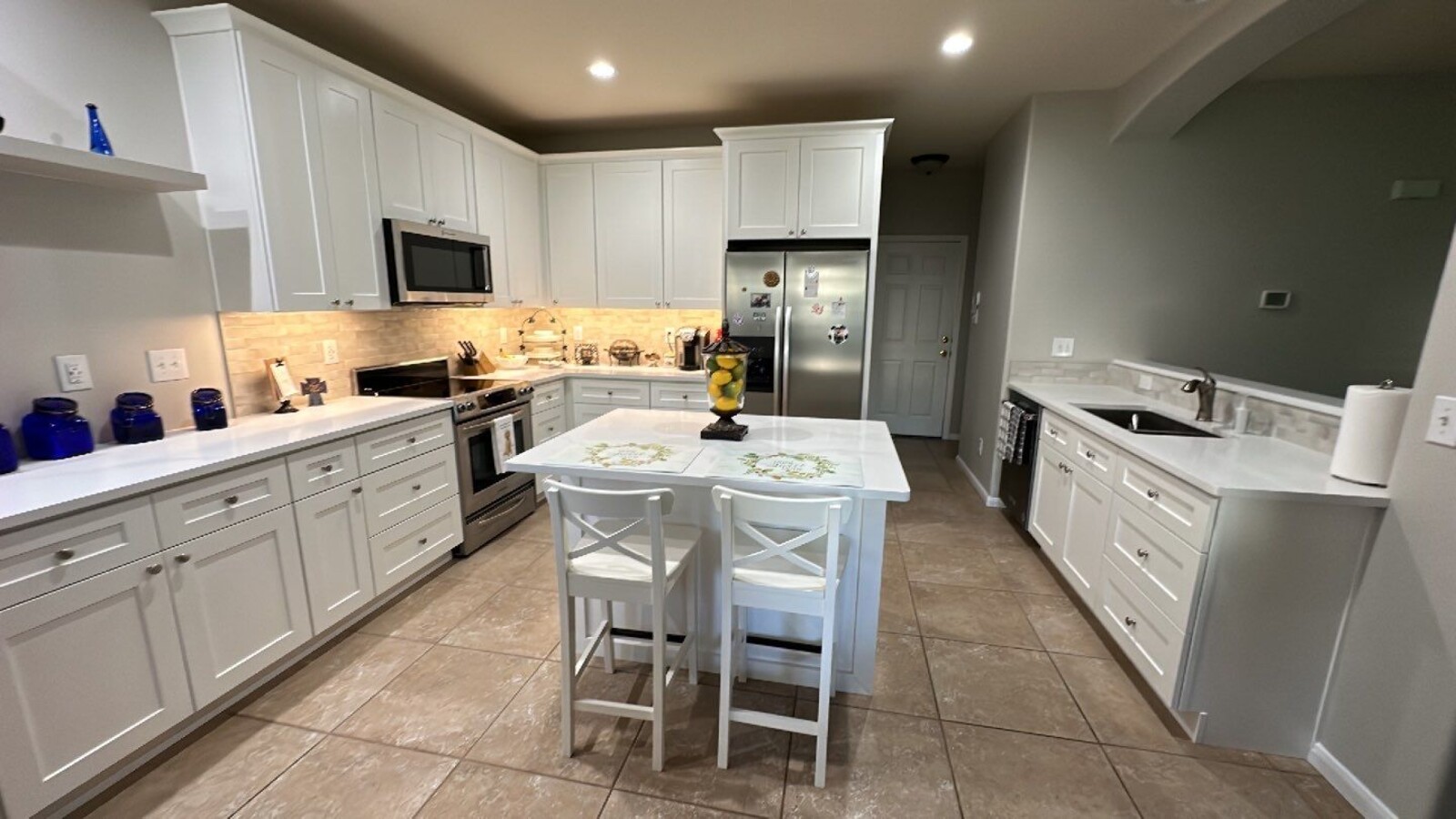 Full view of renovated kitchen with island seating and custom cabinetry by Wade Caldwell Construction