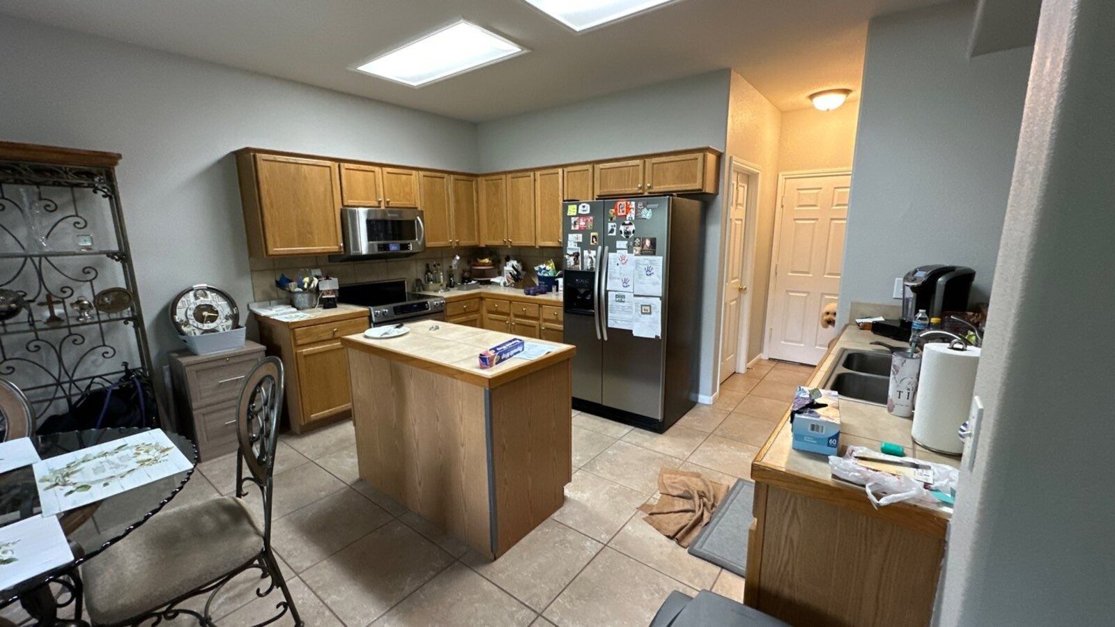 Full kitchen layout prior to renovation featuring oak cabinets and tiled island by Wade Caldwell Con