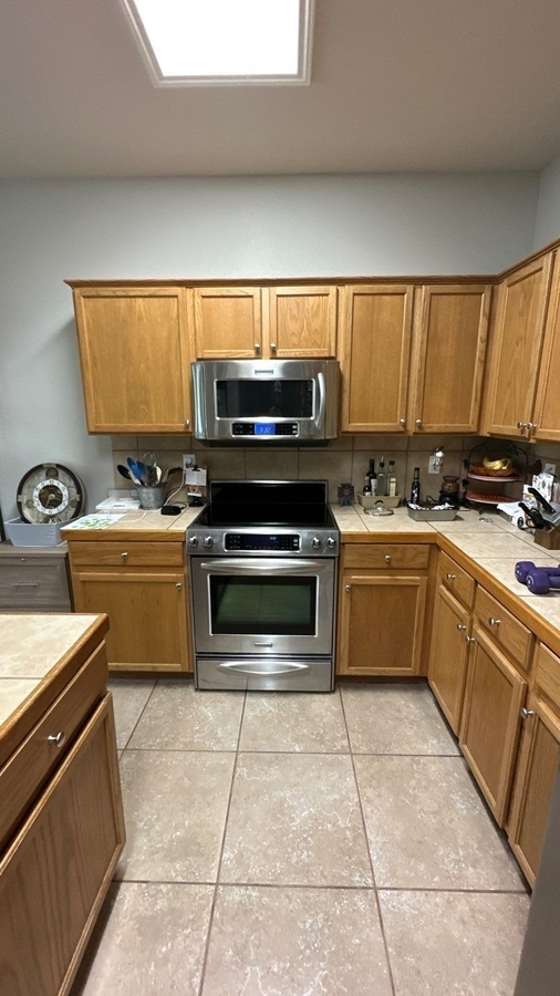 Original kitchen setup with built-in microwave and tiled backsplash before remodel by Wade Caldwell 