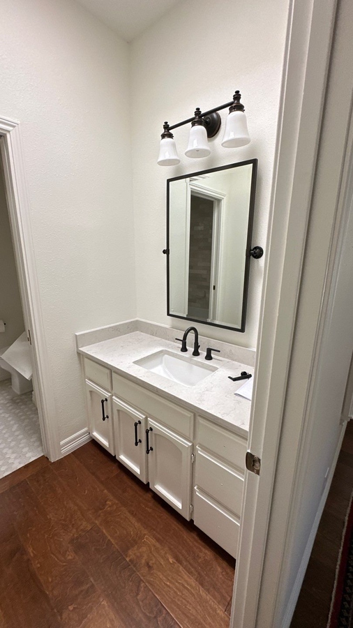 Modern powder room remodel with updated vanity and lighting in Terrell Hills, TX by Wade Caldwe