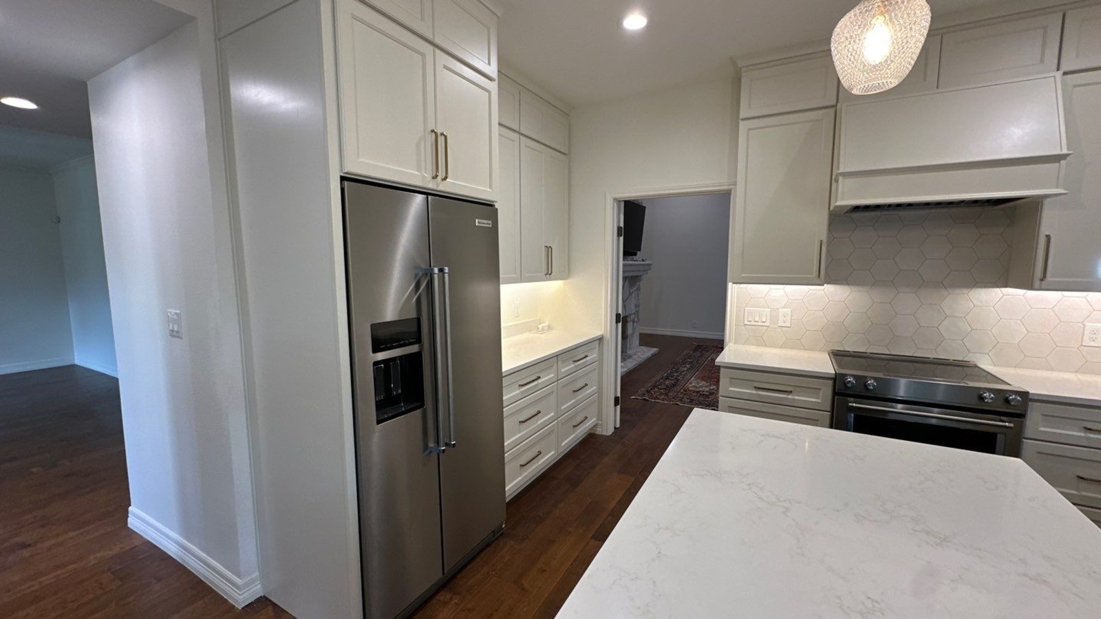 Stainless steel refrigerator set in tall cabinetry during a kitchen remodel by Wade Caldwell Co