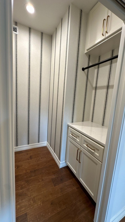 Stylish closet renovation with hardwood floors and modern storage cabinets by Wade Caldwell Con