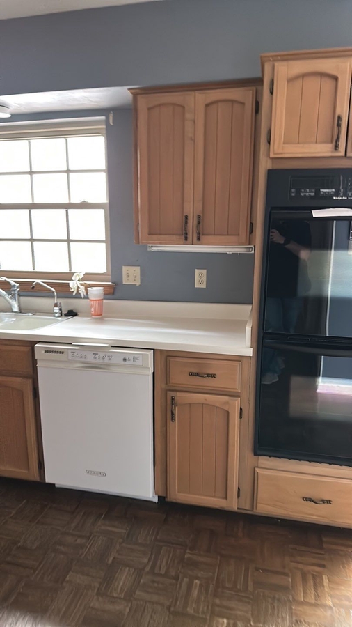 Pre-renovation kitchen with natural wood cabinetry and laminate counters in San Antonio, TX by