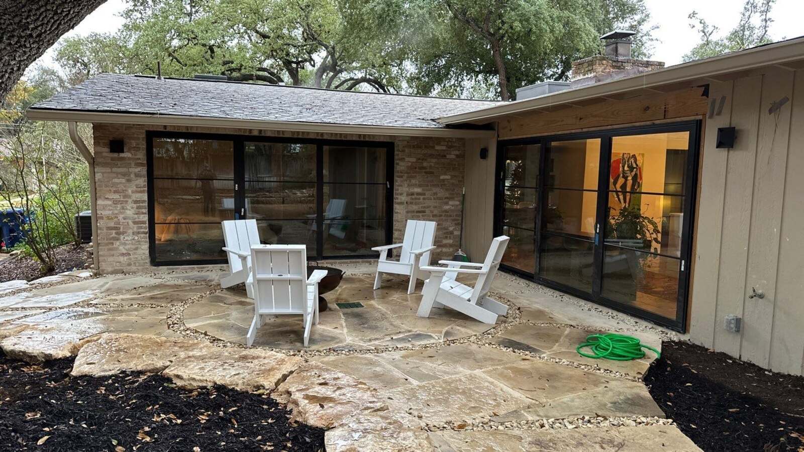Outdoor patio remodel with stone flooring and Adirondack chairs in Shavano Park, TX by