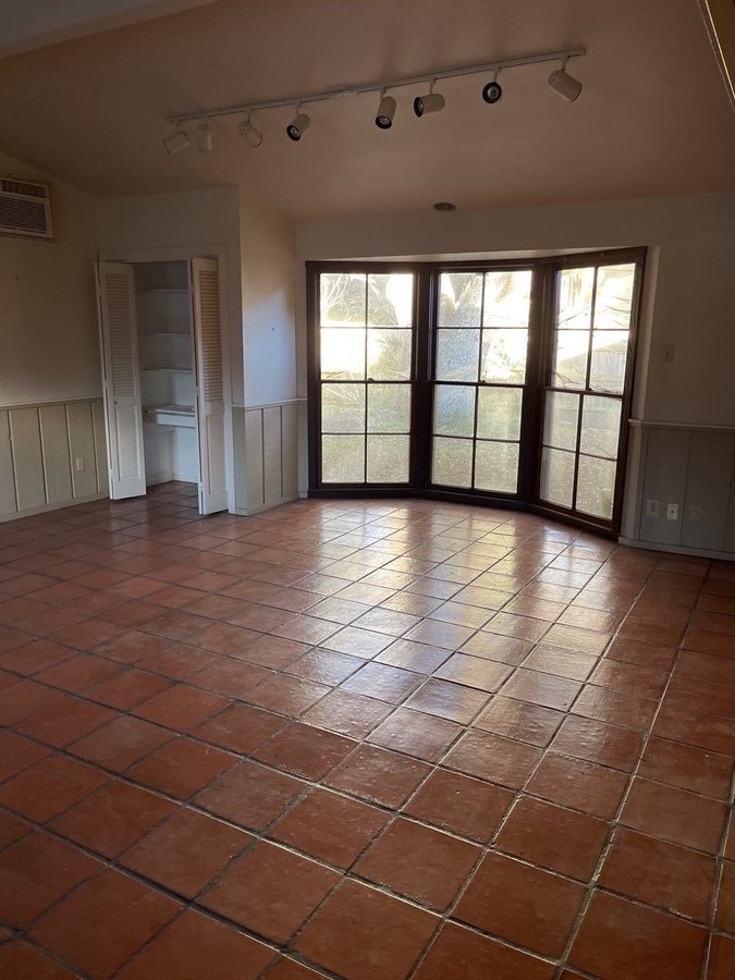 Home interior awaiting remodel in San Antonio featuring bay windows and track lightin
